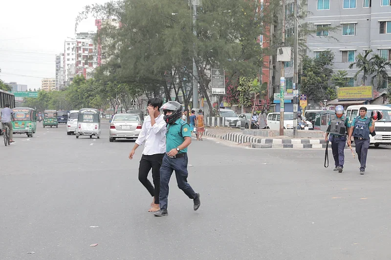 Police taking a protester away from ECB Chattar area in Dhaka on 29 July 2024.